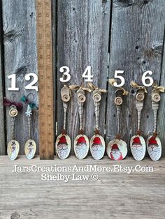 there are seven santa claus key chains in front of a wooden fence and measuring tape