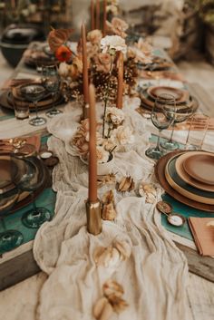 a long table is set with plates and place settings