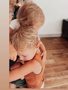 two young children hugging each other on the floor