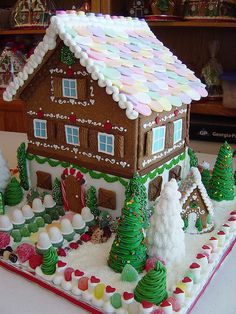 a gingerbread house is decorated with icing and candy on the outside for christmas