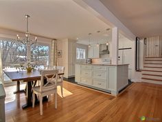 a kitchen and dining room with hardwood floors, white cabinets and an open floor plan