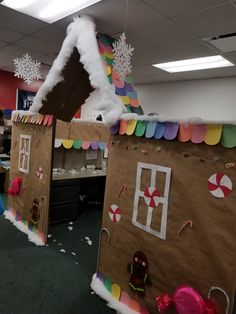 an office cubicle decorated with gingerbread houses and candy canes on the floor