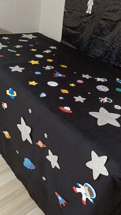 a black bed with space themed sheets on it