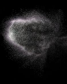 white powder flying in the air on a black background