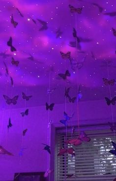 the ceiling is covered in purple lights and butterflies