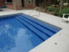 an empty swimming pool in front of a house