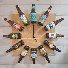 a clock made out of beer bottles sitting on top of a wooden table