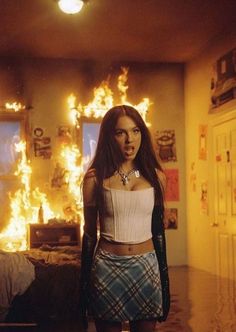 a woman standing in front of a fire filled room