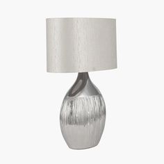 a silver lamp with a white shade on it