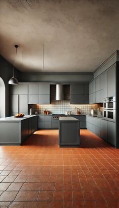 an empty kitchen with red tile flooring and gray cabinets