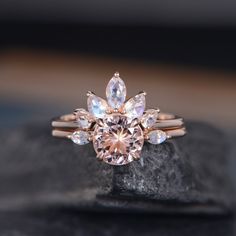 a close up of a ring with an oval shaped diamond in the center on a rock