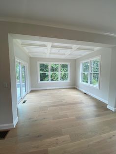 an empty living room with hard wood flooring and white painted walls on both sides