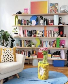 a living room filled with lots of furniture and bookshelves on top of shelves