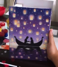 someone is holding up a card with a couple in a boat floating on the water