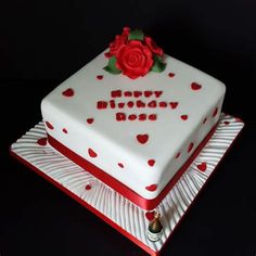 a birthday cake decorated with hearts and a rose