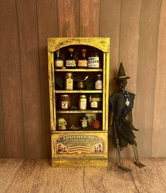 a doll is standing next to an old fashioned medicine cabinet