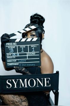 a woman holding a movie clapper over her face with the word symone written on it