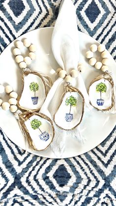 four white dishes with blue and green designs on them are sitting on a patterned tablecloth