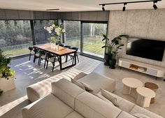 a living room filled with furniture and a large flat screen tv mounted to the wall