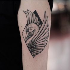 a black and white bird tattoo on the arm