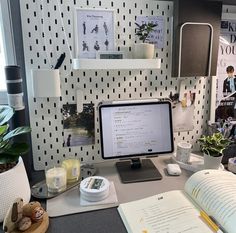 an open book on a desk next to a computer monitor and keyboard with a mouse