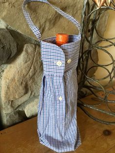 a blue and white gingham bag sitting on top of a wooden table next to a stone wall