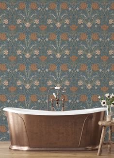 a bath tub sitting on top of a wooden floor next to a wallpaper covered in flowers