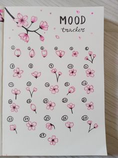 a card with pink flowers on it and the words mood tracker written in black ink