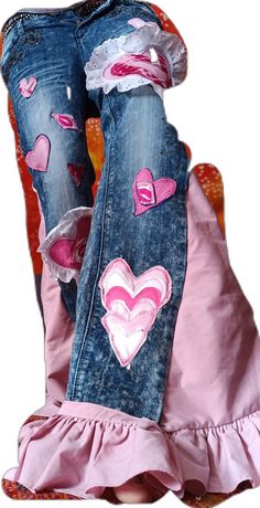 two pairs of jeans with hearts on them are sitting next to each other in a pink dress