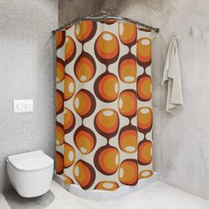 an orange and brown shower curtain next to a white toilet in a bathroom with marble walls