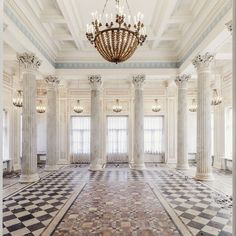 an ornate room with columns and chandelier