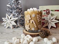 a coffee mug with marshmallows and christmas decorations