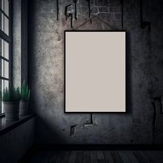 an empty frame hanging on the wall next to a potted plant in a dark room