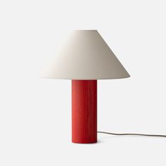 a red lamp sitting on top of a white table