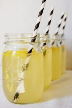 three mason jars filled with yellow liquid and black and white striped paper drinking straws