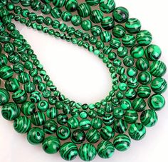 green glass beads are arranged on a white surface