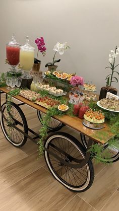 a wooden table topped with lots of food on top of a hard wood floor next to a wall