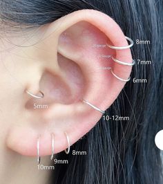 three different types of ear piercings on the side of a woman's ear