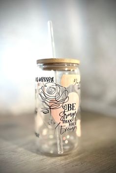 a glass jar with a straw in it sitting on a table