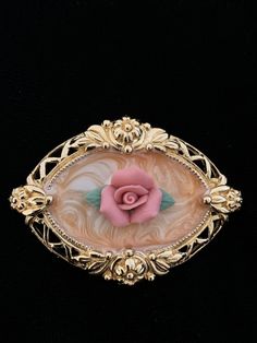 1980s Avon Gold Filagree Enamel Rose Brooch is in excellent/mint vintage condition. See photos and video for actual depiction. The gold tone filagree border is immaculate. The peach swirl enamel is encloses a porcelain pink rose. Vintage Rose Gold Brooches For Wedding, Vintage Rose Gold Wedding Brooches, Vintage Rose Brooch Jewelry, Vintage Rose Jewelry With Brooch, Vintage Rose Brooch, Rose Brooch, Pink Rose, Vintage Gold, Brooch Pin