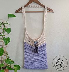 a crocheted bag hanging on a wall next to a potted plant