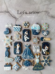 an assortment of decorated cookies on top of a white countertop with the words let's snow written above it