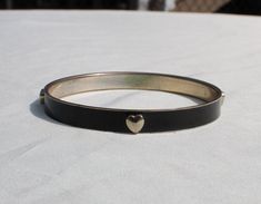 Lovely black enamel bangle bracelet with intermittent silver tone metal 3D hearts in a silver tone metal setting.  So versatile.  It is in really good vintage condition, some manufacturer defects.   Measures:  2 5/8 inches in diameter inside an 1/4 inch wide 3d Hearts, Enamel Bangle, 3d Heart, Metal Bracelet, Metal Bracelets, Black Enamel, Silver Heart, Bangle Bracelet, Bangle Bracelets