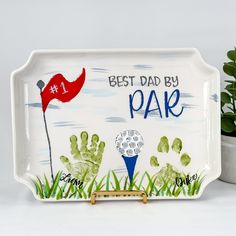 a handprinted golf themed tray with the words best dad by park on it