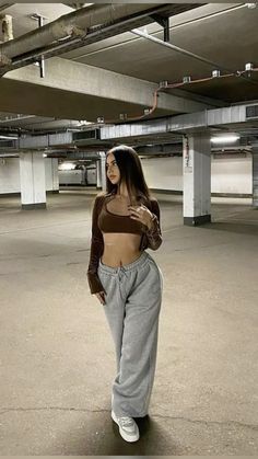 a woman standing in an empty parking garage