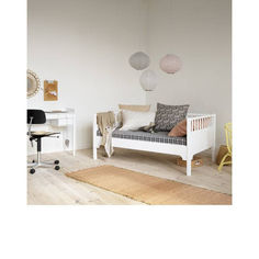 a white day bed sitting on top of a hard wood floor next to a desk