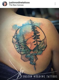 the back of a woman's shoulder with watercolor tattoos on it and trees