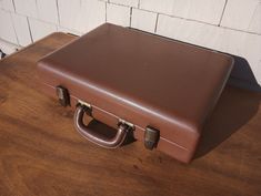 a brown suitcase sitting on top of a wooden table