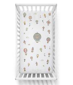 a white crib with hot air balloons on it