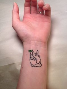 a person with a small tattoo on their wrist that has a cartoon character drawn on it